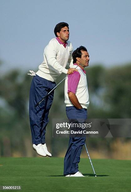 Jose-Maria Olazabal of Spain jumps up and uses the shoulders of compatriot Seve Ballesteros to get a better view of the course during the 29th Ryder...