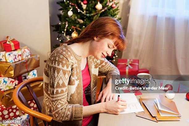 woman writing christmas cards. - christmas cards stock pictures, royalty-free photos & images