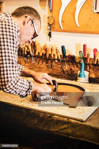 a saddle maker making a custom made saddle.  real person, real life. - saddler stock pictures, royalty-free photos & images