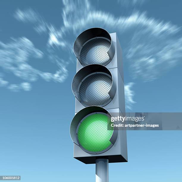 green light in front of a blue sky - stoplight fotografías e imágenes de stock