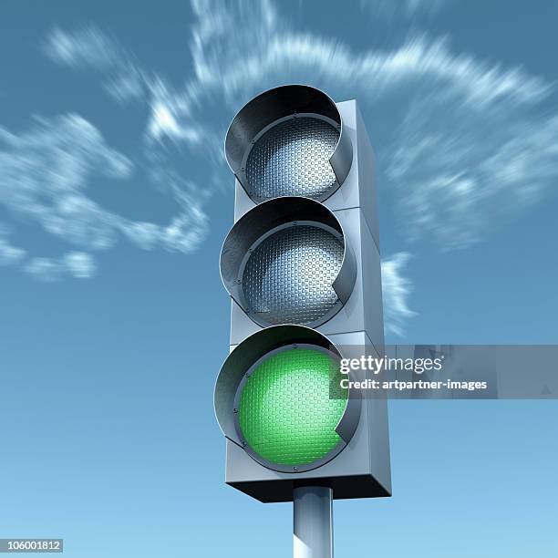 green light in front of a blue sky - stoplight foto e immagini stock