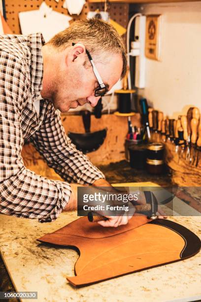 a saddle maker making a custom made saddle.  real person, real life. - saddler stock pictures, royalty-free photos & images