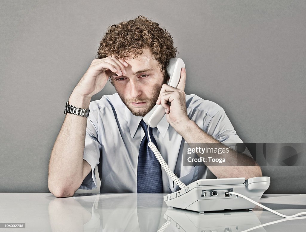 Businessman on phone listening to bad news