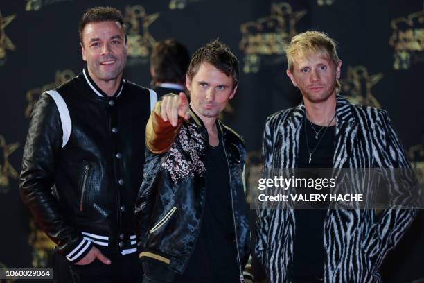 British rock band Muse composed by bassist Christopher Wolstenholme, singer Matthew Bellamy and drummer Dominic Howard pose on the red carpet upon...