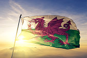 Wales Welsh United Kingdom Great Britain flag textile cloth fabric waving on the top sunrise mist fog