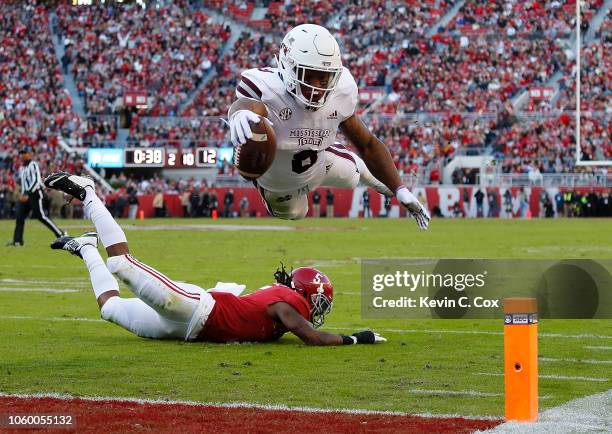Kylin Hill of the Mississippi State Bulldogs dives for a touchdown over Shyheim Carter of the Alabama Crimson Tide at Bryant-Denny Stadium on...