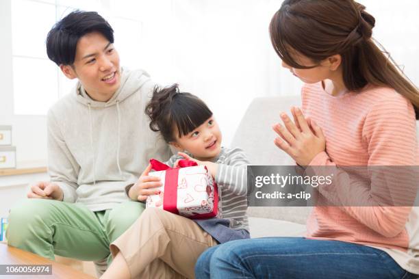 a girl trying to open a present - girl sitting with legs open stock pictures, royalty-free photos & images