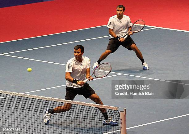 Sonchat Ratiwatana of Thailand plays a backhand with team mate Sanchai Ratiwatana of Thailand looking on during their doubles match against Robert...