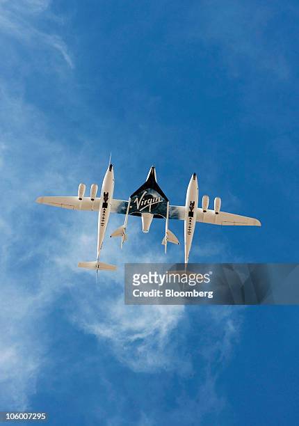 The WhiteKnightTwo mothership, carrying SpaceShipTwo , performs a flyover during an event commemorating the completion of the Virgin Galactic...