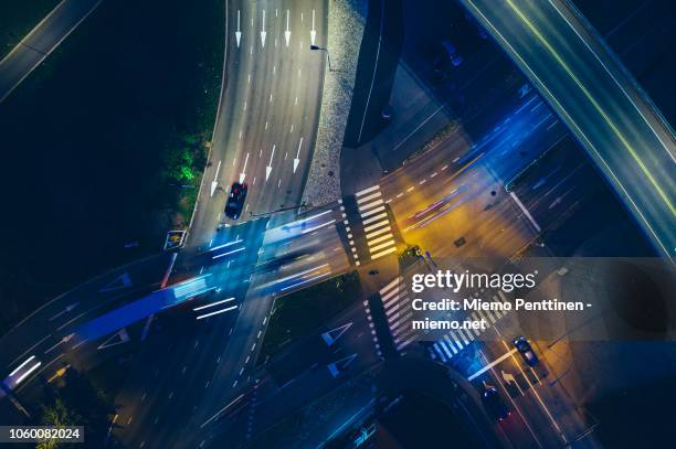 nighttime aerial of a road intersection with motion-blurred traffic - aerial view photos stockfoto's en -beelden