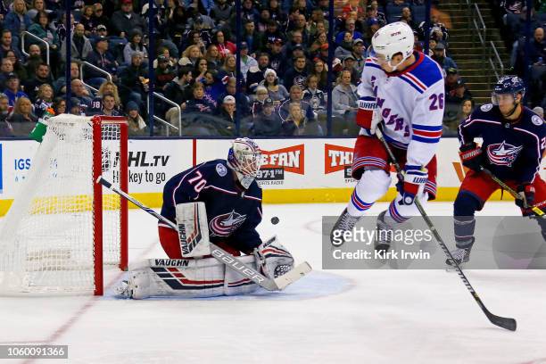 Jimmy Vesey of the New York Rangers jumps out of the way of the puck while screening Joonas Korpisalo of the Columbus Blue Jackets during the first...