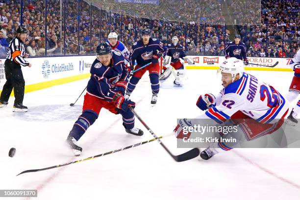 Cam Atkinson of the Columbus Blue Jackets and Kevin Shattenkirk of the New York Rangers battle for control of the puck during the first period on...