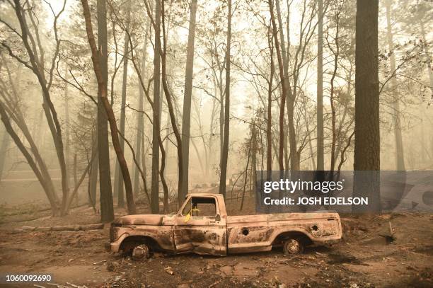Burnt out truck is seen in Paradise, California after the Camp fire tore through the area on November 10, 2018. - Firefighters in California on...