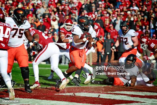Running back Justice Hill of the Oklahoma State Cowboys scores against the Oklahoma Sooners at Gaylord Family Oklahoma Memorial Stadium on November...