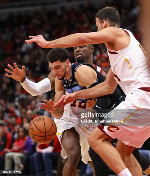 Zach LaVine of the Chicago Bulls drives between David Nwaba and Ante Zizic of the Cleveland Cavaliers at the United Center on November 10, 2018 in...