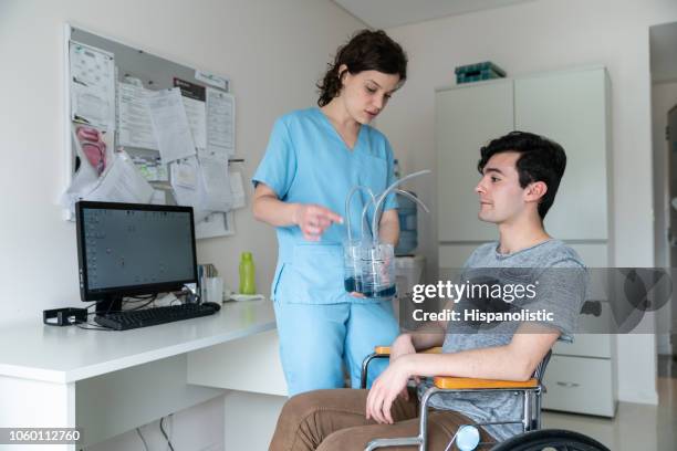 therapeuten geben anweisungen an patienten im rollstuhl von einer atemübung mit einem spirometer - atmungsorgan stock-fotos und bilder