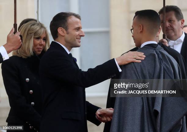 French President Emmanuel Macron and his wife Brigitte Macron welcome Moroccan King Mohammed VI and his son Morocco's Prince Moulay Hassan as they...