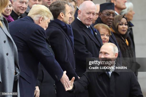 Russian President Vladimir Putin shakes hands with US President Donald Trump as he arrives to attend a ceremony at the Arc de Triomphe in Paris on...