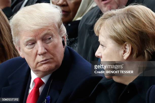 President Donald Trump and German Chancellor Angela Merkel speak as they attend a ceremony at the Arc de Triomphe in Paris on November 11, 2018 as...