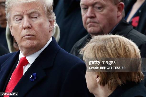 President Donald Trump looks at German Chancellor Angela Merkel as they attend a ceremony at the Arc de Triomphe in Paris on November 11, 2018 as...