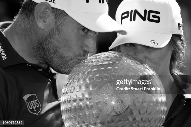 Lee Westwood of England and Caddie and partner Helen Storey kiss the trophy after Lee Westwood wins during Day Four of the Nedbank Golf Challenge at...