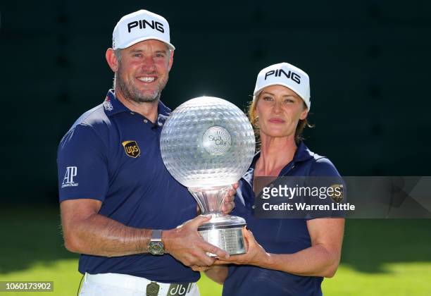 Lee Westwood of England and Caddie and partner Helen Storey lift the trophy after Lee Westwood wins during Day Four of the Nedbank Golf Challenge at...