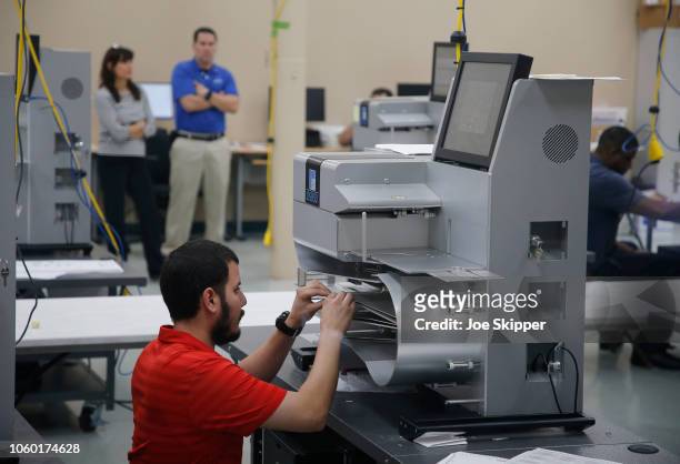 An elections official works on a counting machine as it was calibrated prior to the start of a recount of all votes at the Broward County Supervisor...