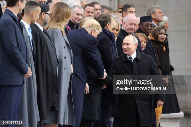Russian President Vladimir Putin shakes hands with US President Donald Trump as he arrives to attend a ceremony at the Arc de Triomphe in Paris on...