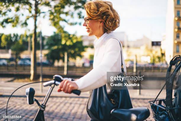 glückliche frau mit dem fahrrad in die innenstadt - brille fluss stadt stock-fotos und bilder