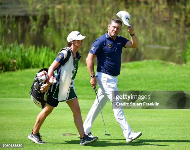 Lee Westwood of England waves his cap to acknowledge the fans as he walks with his girlfriend Helen Storey on the 18th hole during the final round of...