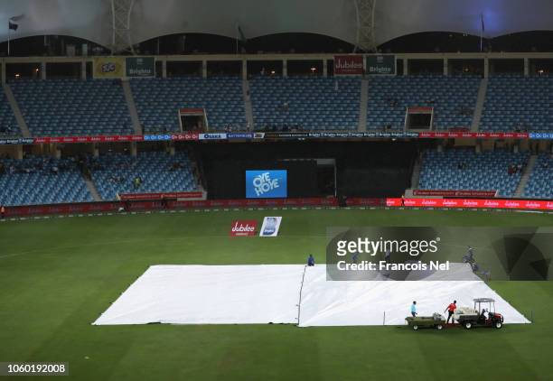 Ground staff pull the covers over the wicket area as rain sets in during the 3rd One Day International match between Pakistan and New Zealand at...