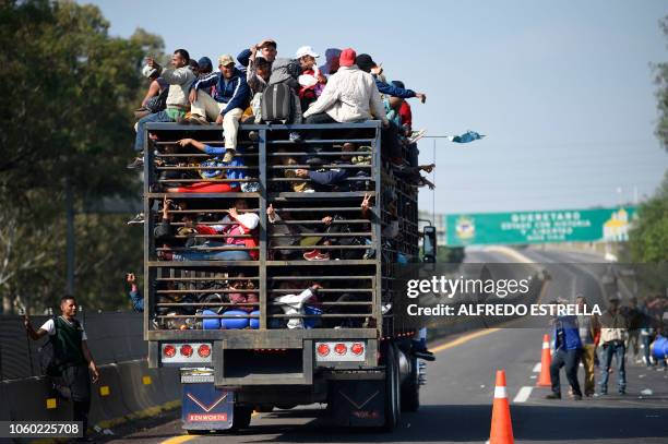 Central American migrants -mostly honduran- taking part in a caravan to the US, are pictured on board a truck heading to Irapuato in the state of...