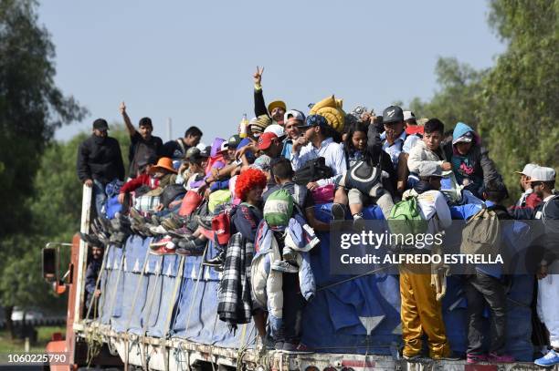 Central American migrants -mostly honduran- taking part in a caravan to the US, are pictured on board a truck heading to Irapuato in the state of...