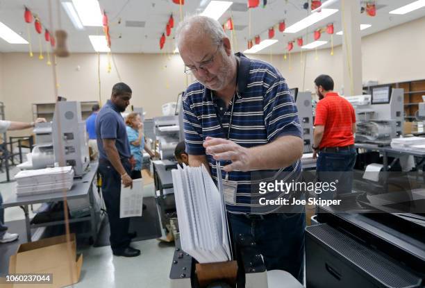 Device is used to straighten ballots before machine counting during a recount at the Broward County Supervisor of Elections office on November 11,...
