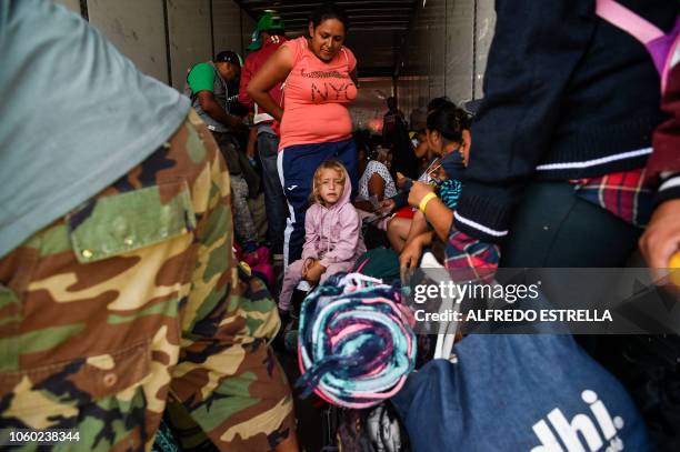 Central American migrants -mostly families with children- taking part in a caravan to the US, get on board a container truck heading to Irapuato in...