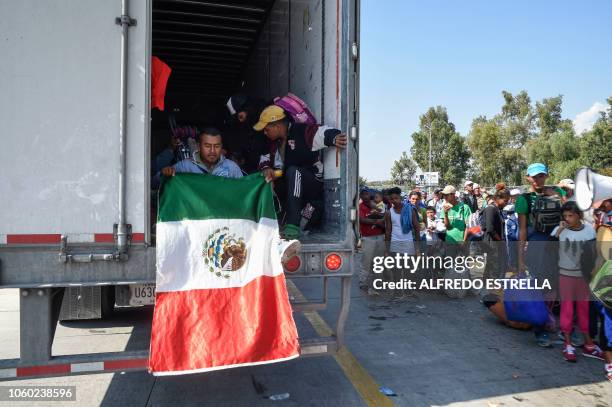 Central American migrants -mostly honduran- taking part in a caravan to the US, get on board a container truck heading to Irapuato in the state of...