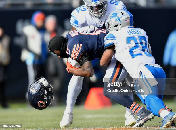 Anthony Miller of the Chicago Bears loses his helmet while being tackled by Quandre Diggs and Christian Jones of the Detroit Lions in the first...