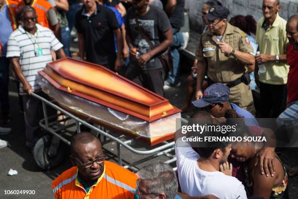 Relatives and friends of Maria Madalena Resende and her grandson, Kaique Resende, two of the fourteen victims of a landslide due to heavy rains in...