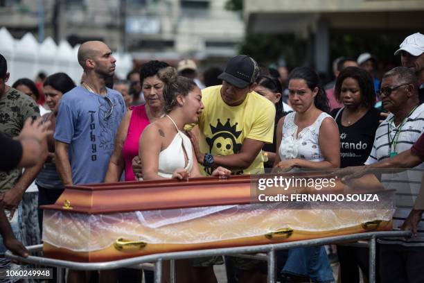 Relatives and friends of Maria Madalena Resende and her grandson, Kaique Resende, two of the fourteen victims of a landslide due to heavy rains in...