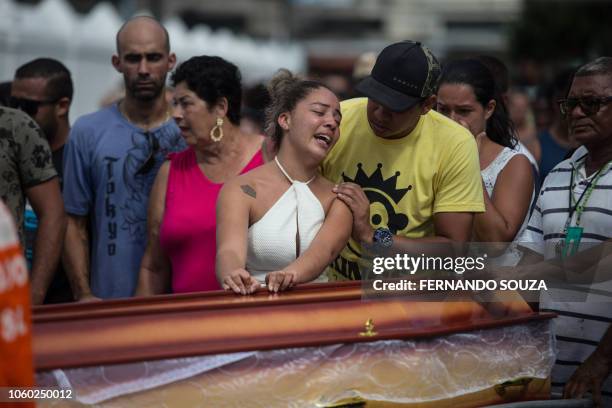 Relatives and friends of Maria Madalena Resende and her grandson, Kaique Resende, two of the fourteen victims of a landslide due to heavy rains in...