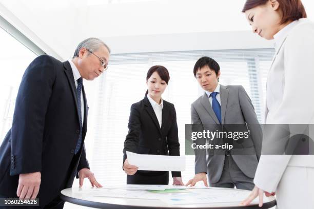 会議をするビジネスマン4人 - surrounding ストックフォトと画像