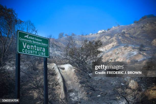 Homes remain intact overlooking fire-damaged hillsides near the border of Los Angeles and Ventura Counties in West Hills, near Malibu, California on...