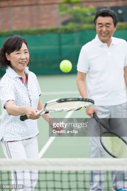 テニスをする中高年カップル - テニス 女性 ストックフォトと画像