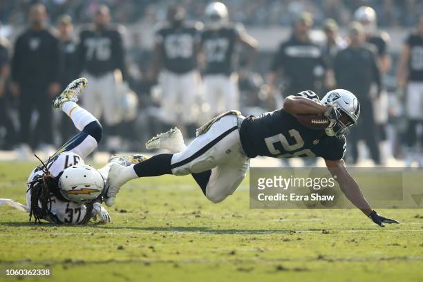 Doug Martin of the Oakland Raiders is tackled by Jahleel Addae of the Los Angeles Chargers during their NFL game at Oakland-Alameda County Coliseum...