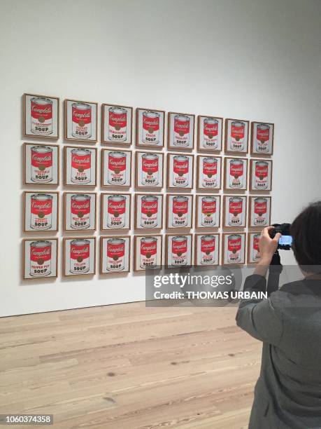 Woman takes a photo of "Campbell's Soup Cans" by late US artist Andy Warhol during a press preview of the exhibition "Andy Warhol - From A to B and...