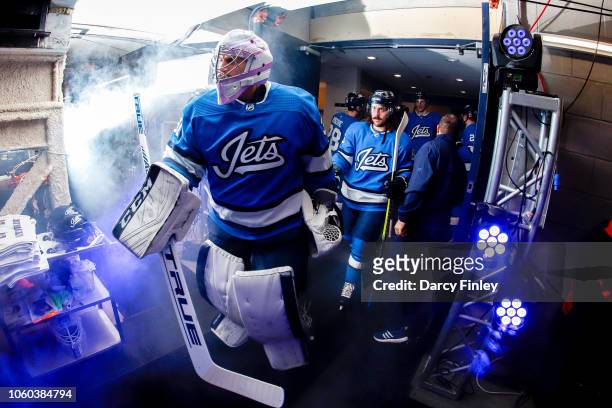 Goaltender Connor Hellebuyck of the Winnipeg Jets leads his teammates to the ice prior to puck drop against the New Jersey Devils at the Bell MTS...