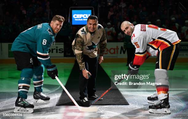 Joe Pavelski of the San Jose Sharks, 10-year army vet Javier Castillo and Mark Giordano of the Calgary Flames at center ice for the ceremonial puck...