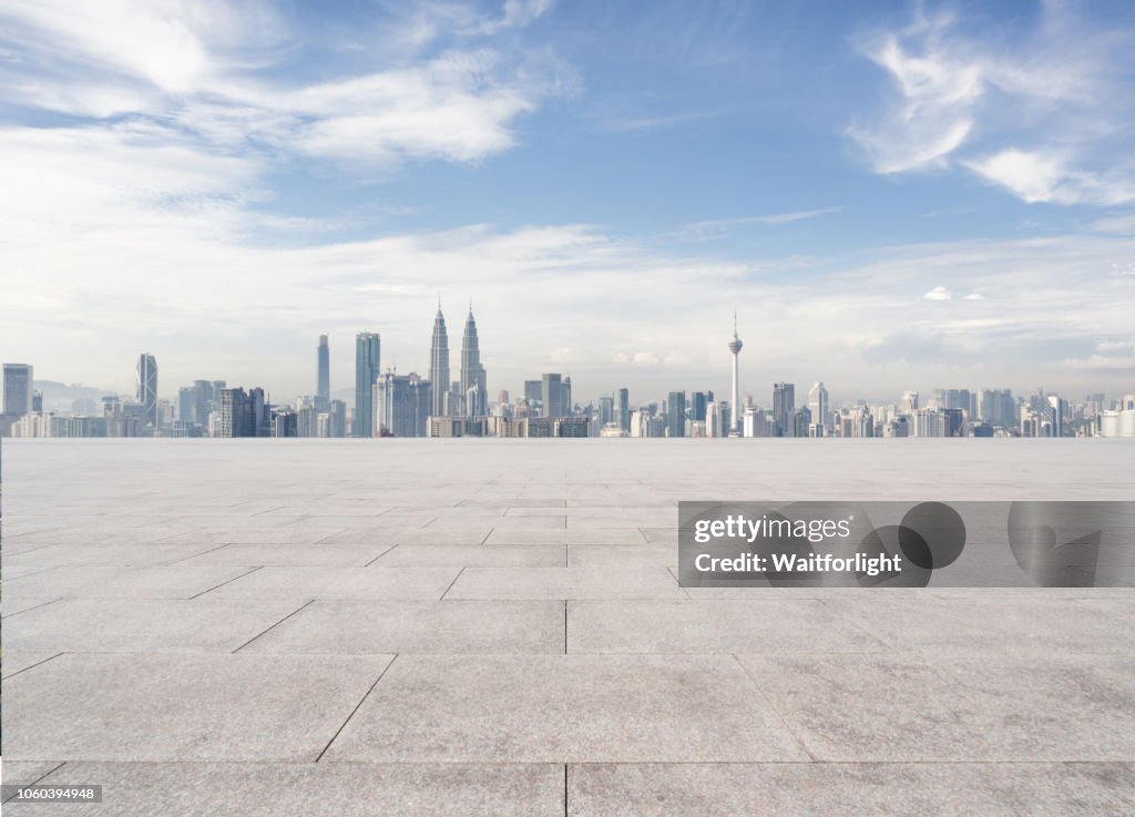 Empty parking lot with Kuala Lumpur skyline background