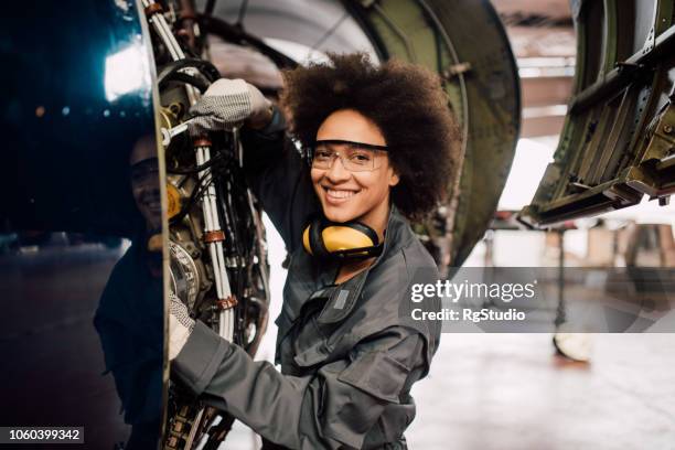 glückliche frau flugzeuge zu reparieren - aircraft mechanic stock-fotos und bilder