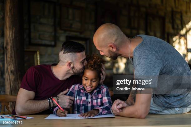 gay couple spending creative time with their daughter - adoption stock pictures, royalty-free photos & images